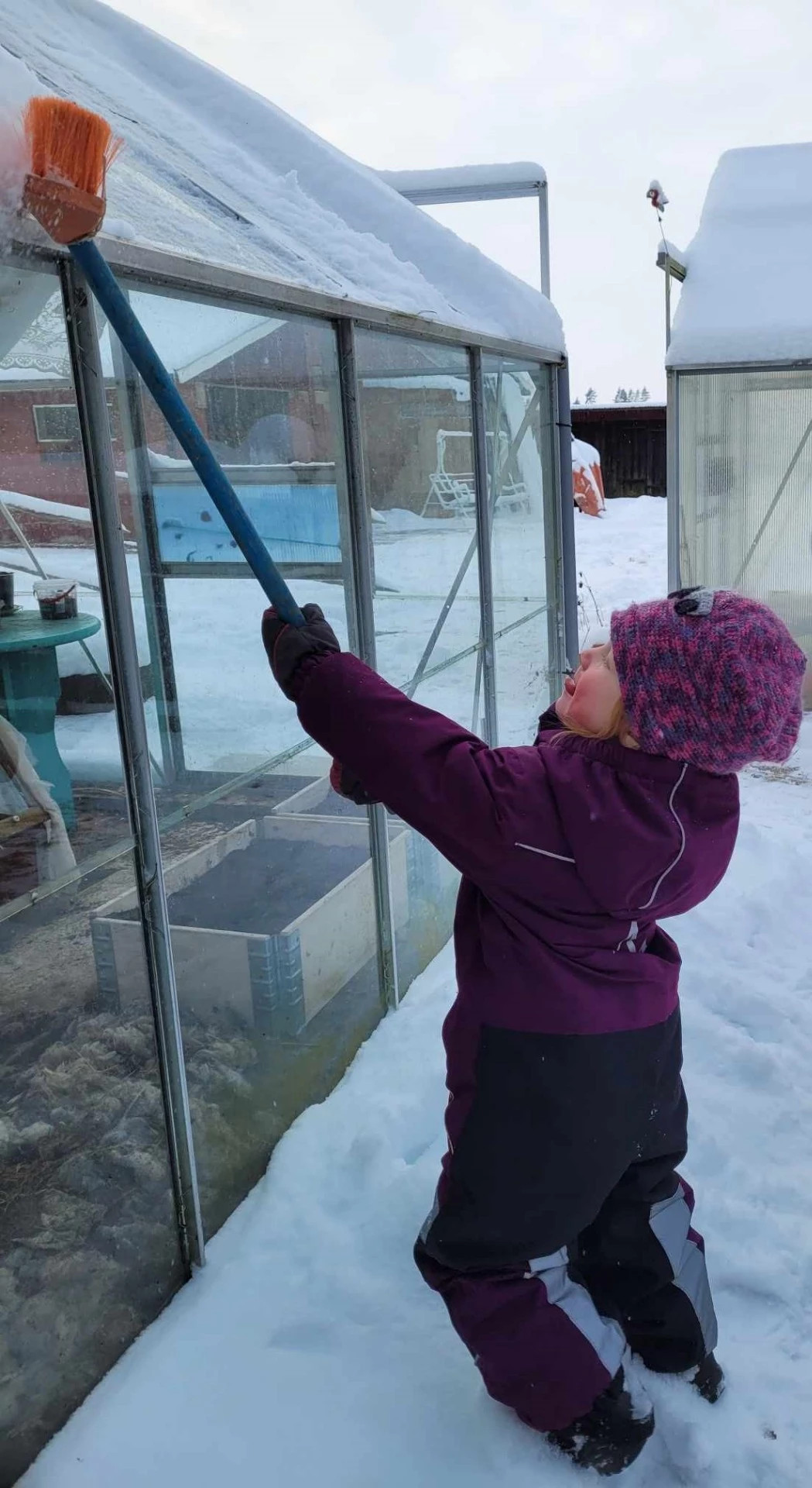 Skotta bort snön med baksidan av en sopborste.